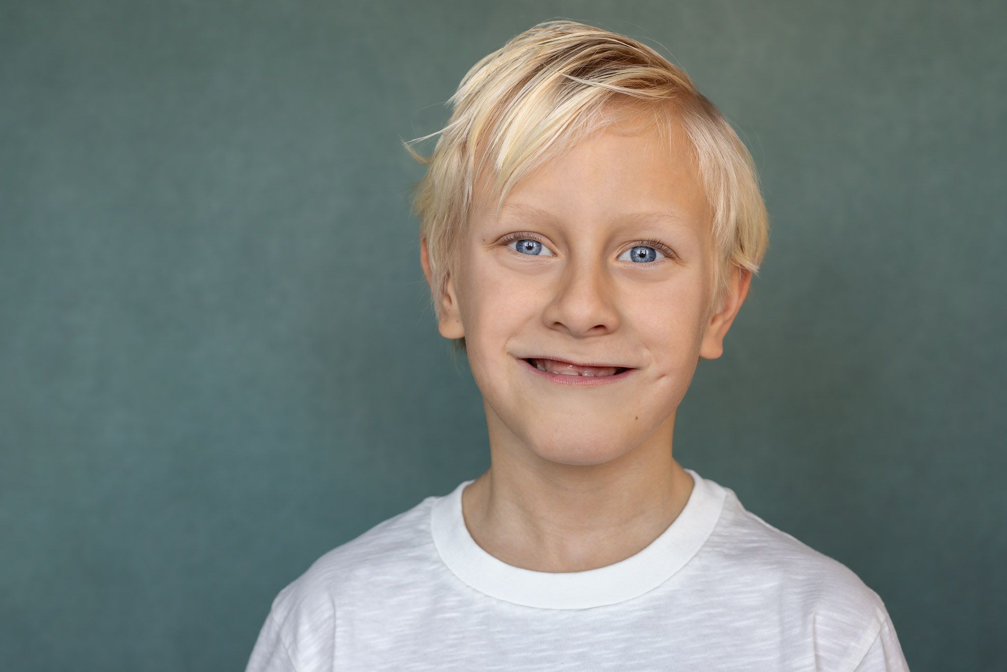 Barbara Kempeneers Fotografie, Kinderportret, sage achtergrond, Jongen met sprekende blauwe ogen en blond haar