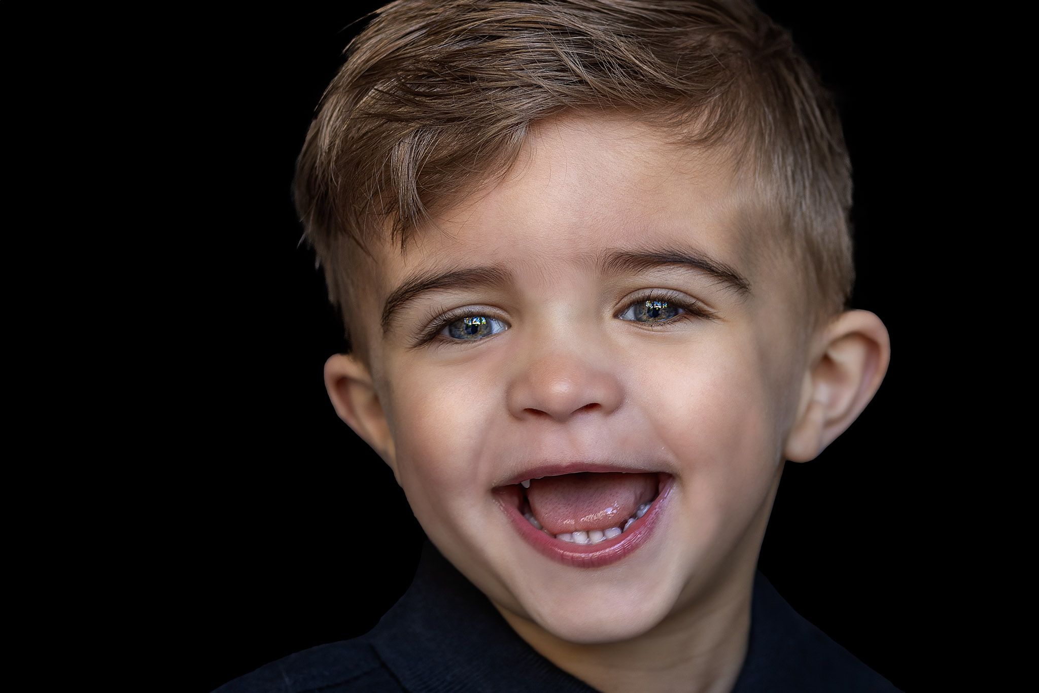 Barbara Kempeneers Fotografie, Kinderportret, Zwarte achtergrond, lachend jongetje, mooie ogen