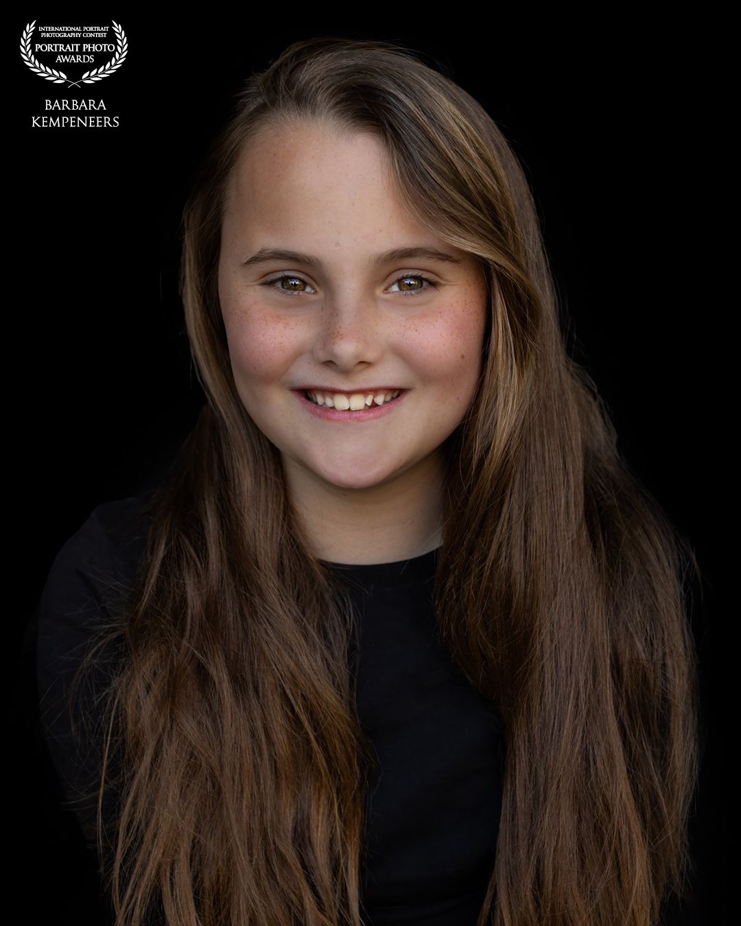 Barbara Kempeneers Fotografie, Kinderportret, Zwarte achtergrond, Mooi meisje, lange bruine haren. Int. Portrait Photo Award gewonnen