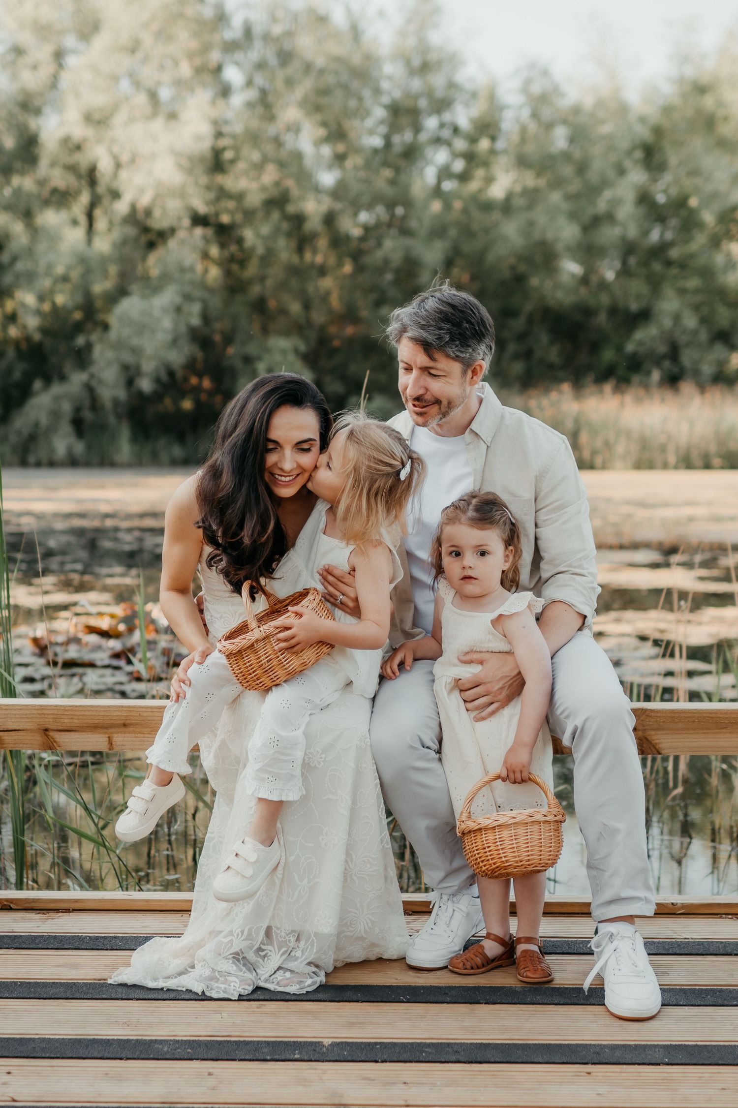 A family sitting on a dock in Leybourne Lakes Country Park, Kent