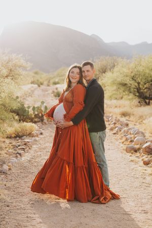 A tender moment shared between a couple on a desert path during golden hour.