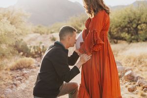 A romantic moment captured in a desert setting with golden sunlight.