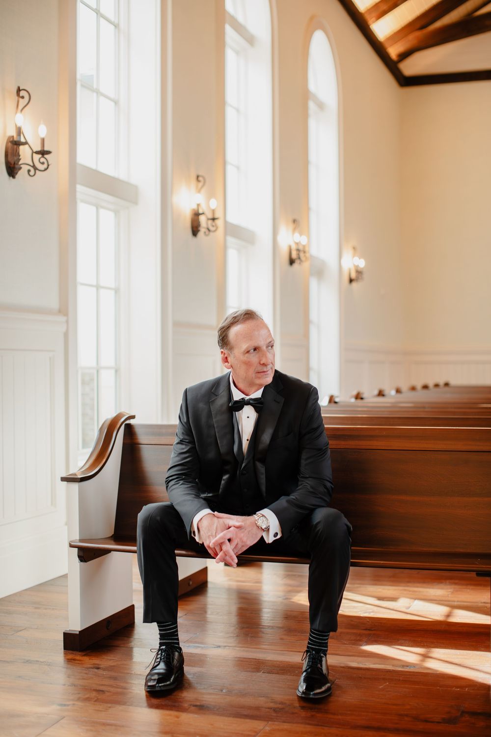 A sequence of photos showing a person in a black suit sitting on a wooden floor in a bright room with white walls.