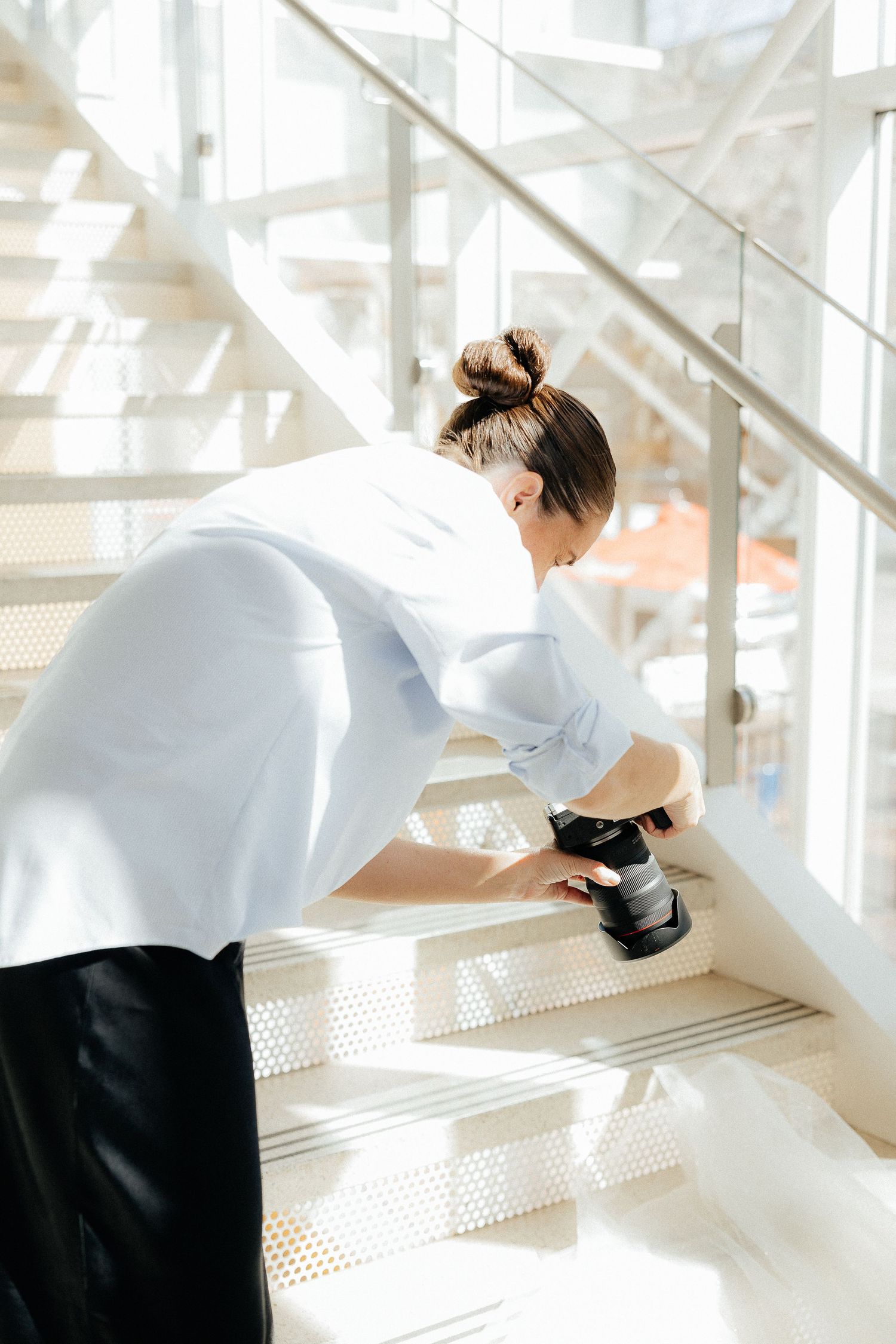 Artistic wedding photography in bright modern stairwell with natural light.
