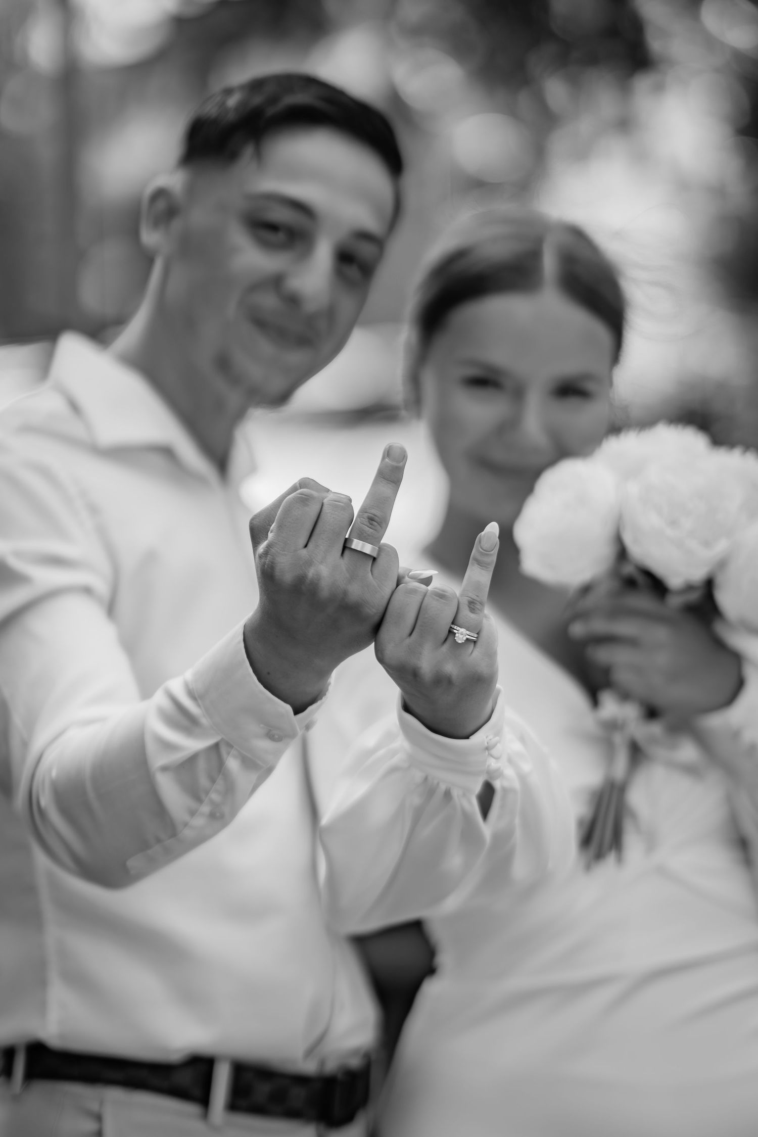 Kreativt bryllupsfoto med fokus på brudeparrets vielsesringe i et sløret romantisk miljø – fotograferet af CHH_foto i Jægerspris, Frederikss