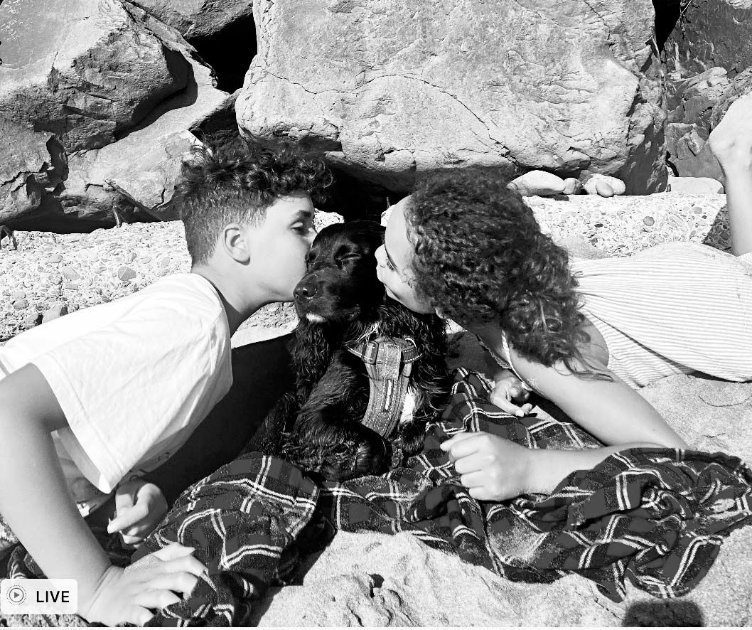 Two people relax on rocky terrain in a casual black and white vintage photograph.