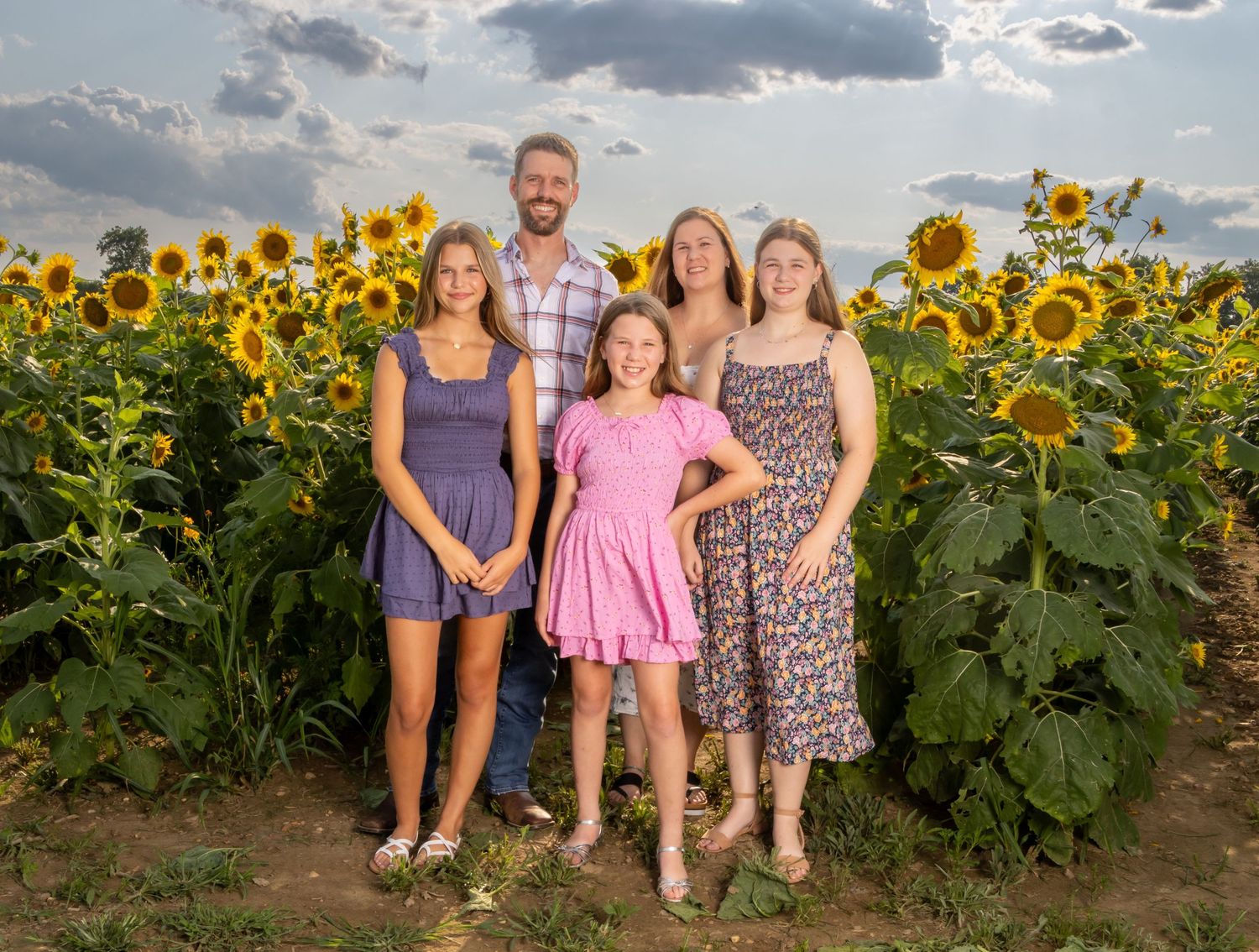 Family of 5 in colorful dresses in a sunflower field. Salem and Gloucester County Family Photographer
