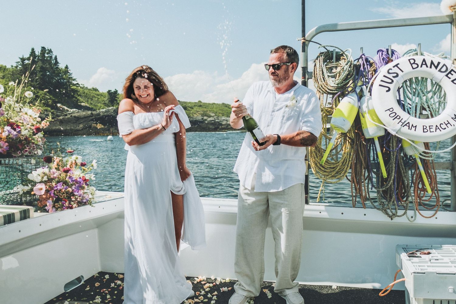 A couple celebrates their wedding by opening a bottle of champagne.
