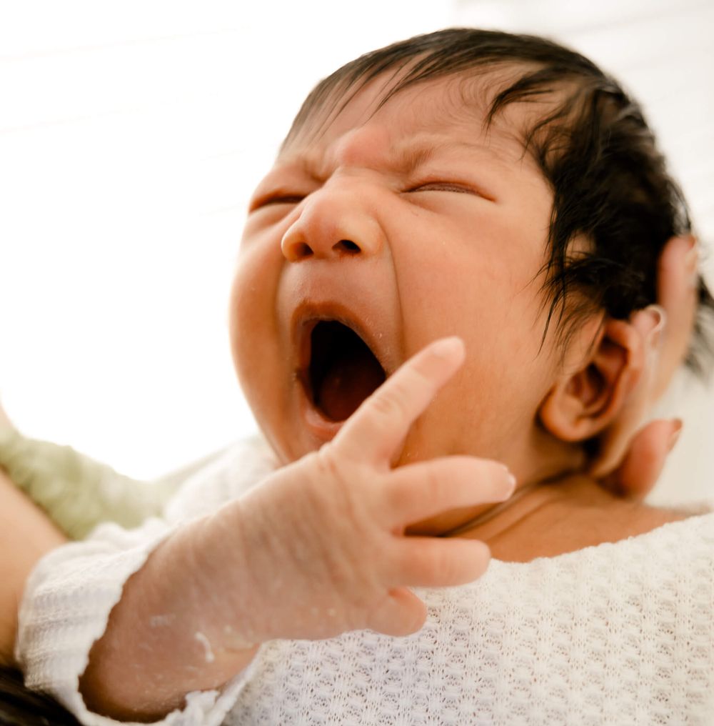 Newborn yawning during cozy lifestyle photography session in Bay Area