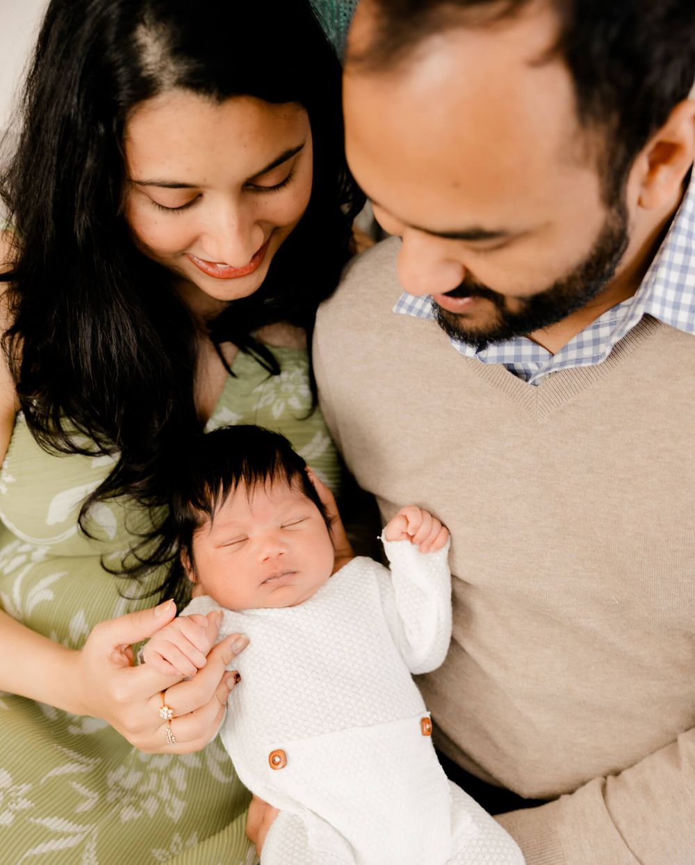 Bay Area lifestyle newborn session with parents snuggling baby in natural light.