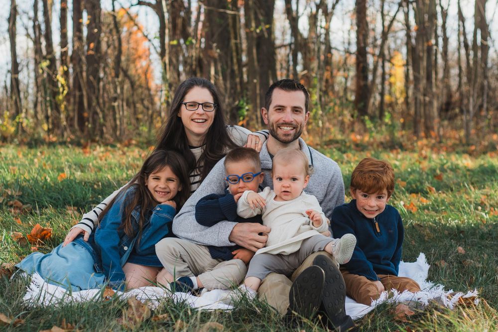 Family smiling during a golden hour lifestyle family photography portrait session in Maybury Park, Michigan.