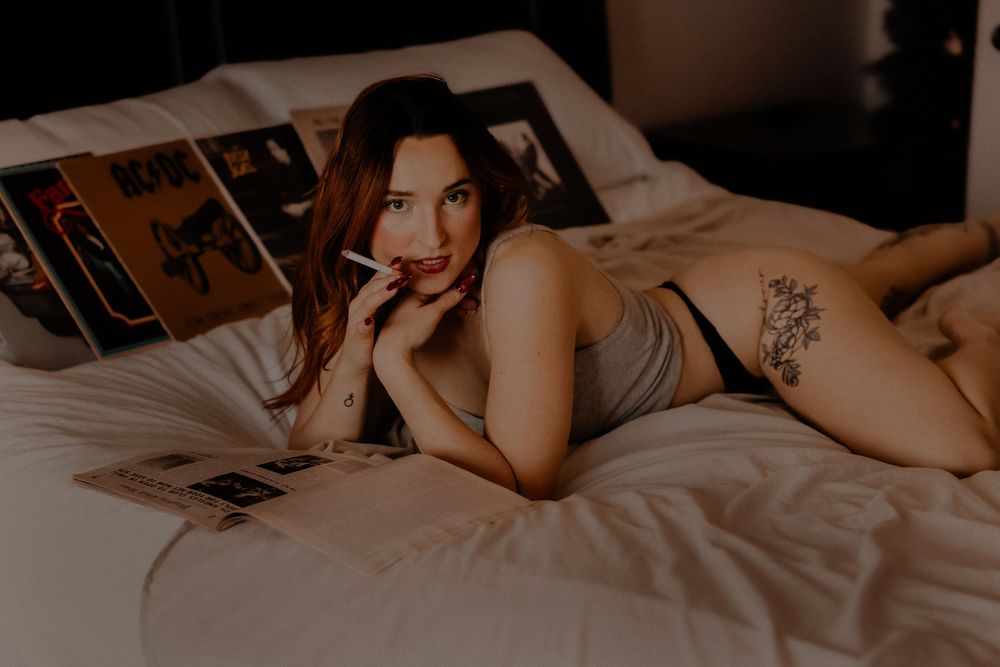 Niche boudoir. holding cigarette to lips woman's photography. 80s 90s photoshoot. retro photoshoot with records