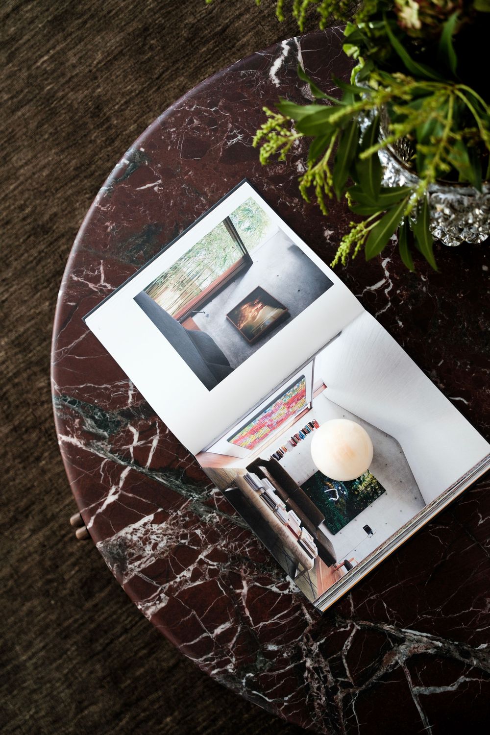 Polaroid photographs displayed on dark marble surface with green plant.