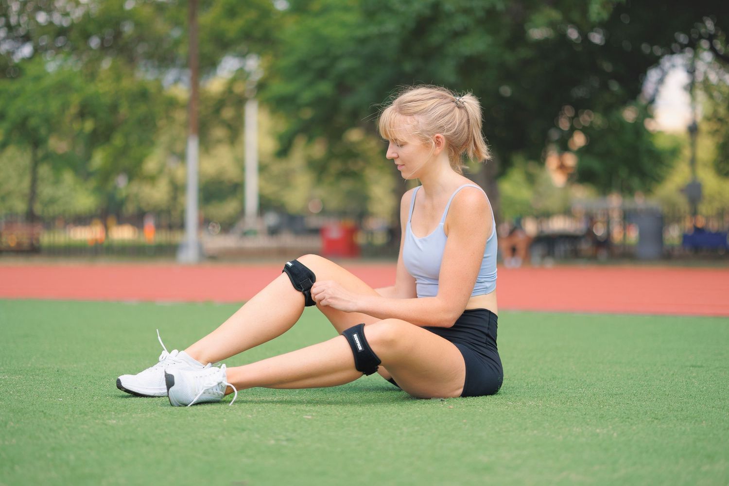 Athletes stretching on a grassy field during outdoor training session.