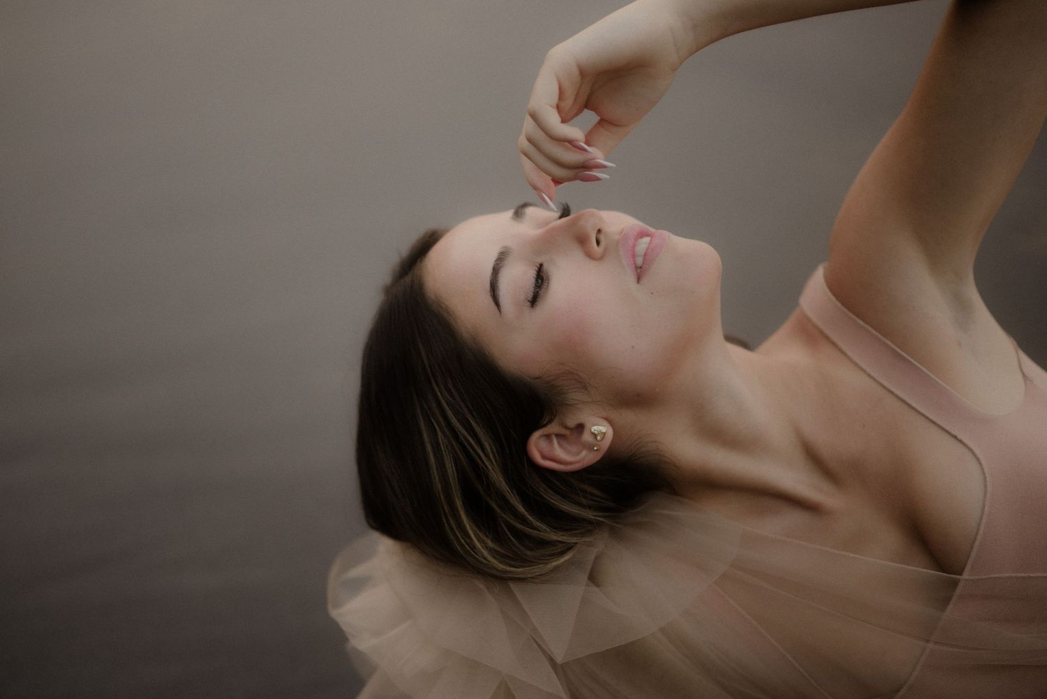 Graceful dance-like poses captured in soft natural light against neutral backdrop.