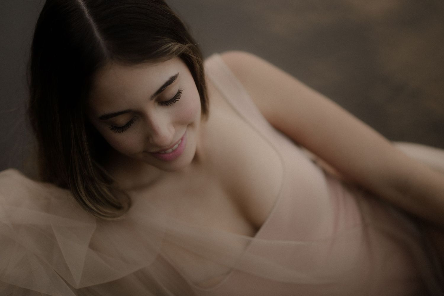 Soft romantic boudoir scene with subtle lighting and gentle shadows.