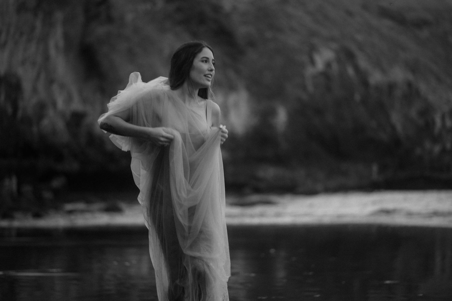 Black and white photo series captures graceful movement in water with moody natural backdrop.