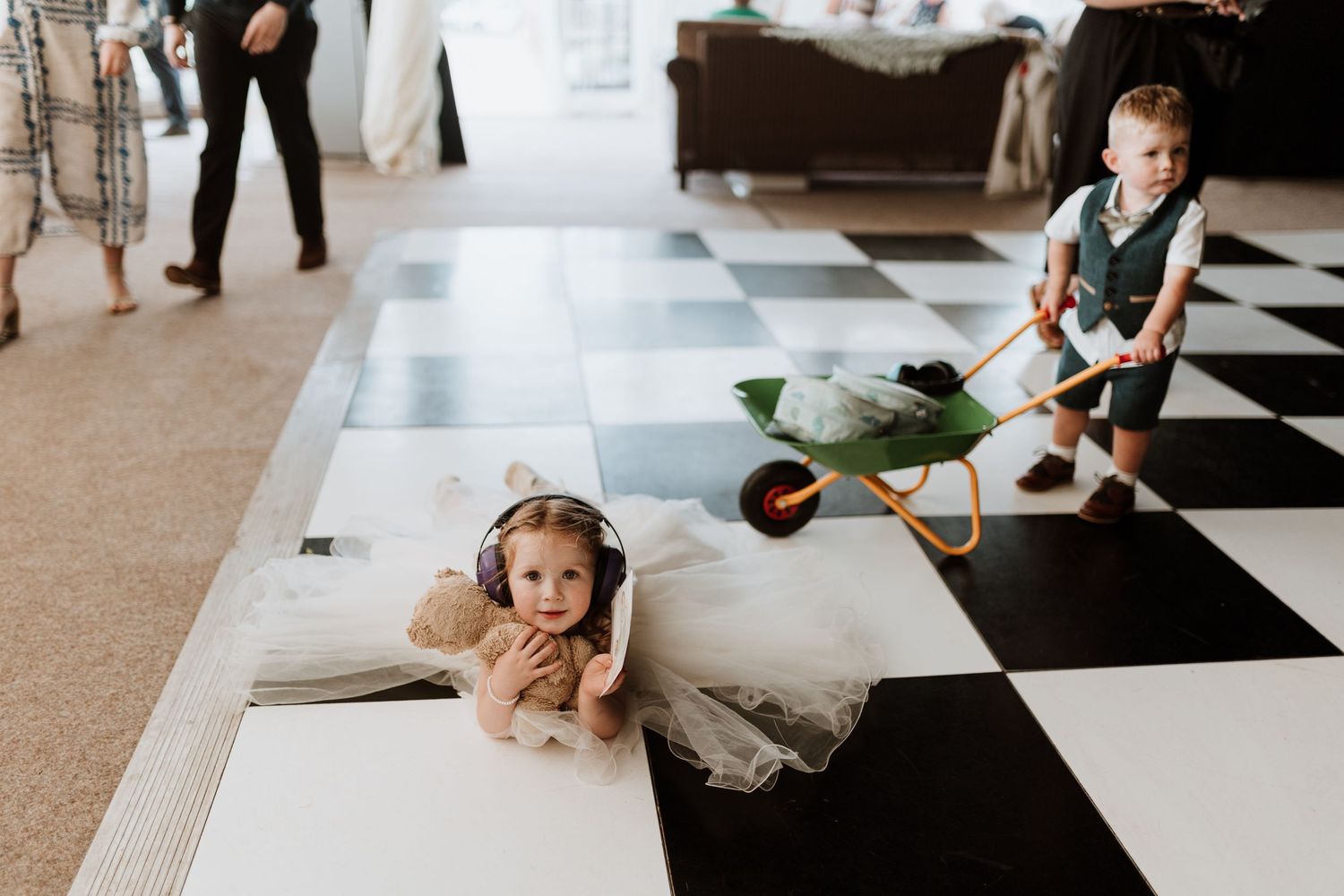 2 children playing on a checkered dance floor before first dance.
