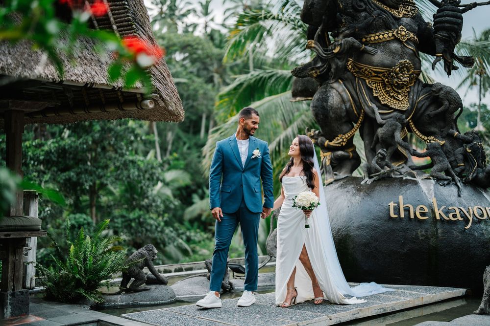 Garden wedding venue path decorated with tropical plants and stone sculptures.