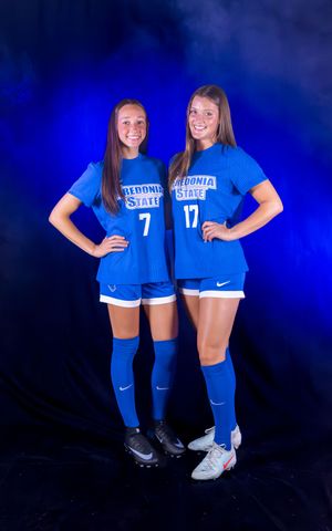 Soccer players in blue Fredonia State uniforms pose together for team photo.