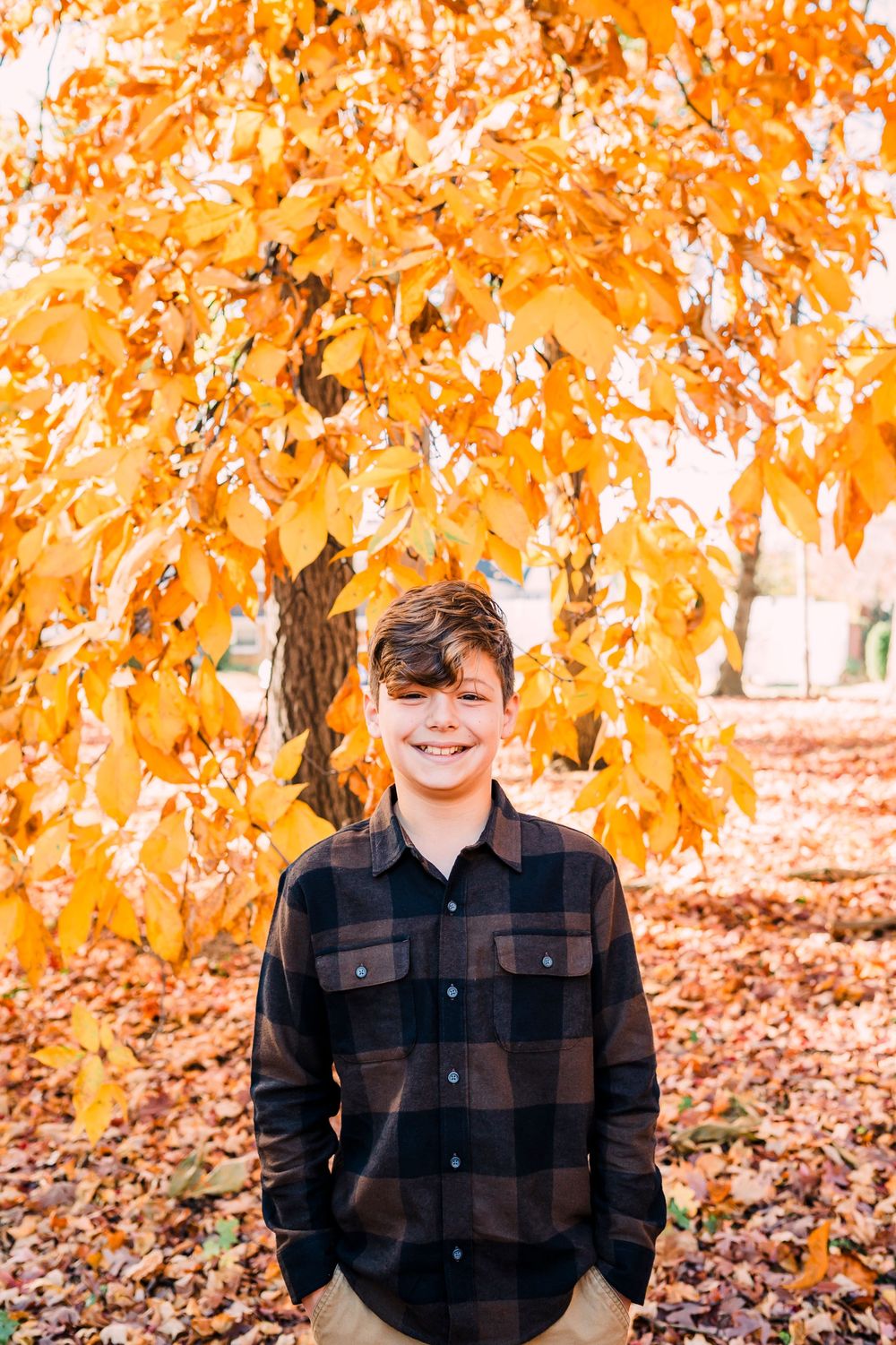 A series of fall portraits showing joyful expressions against vibrant orange autumn foliage and fallen leaves.