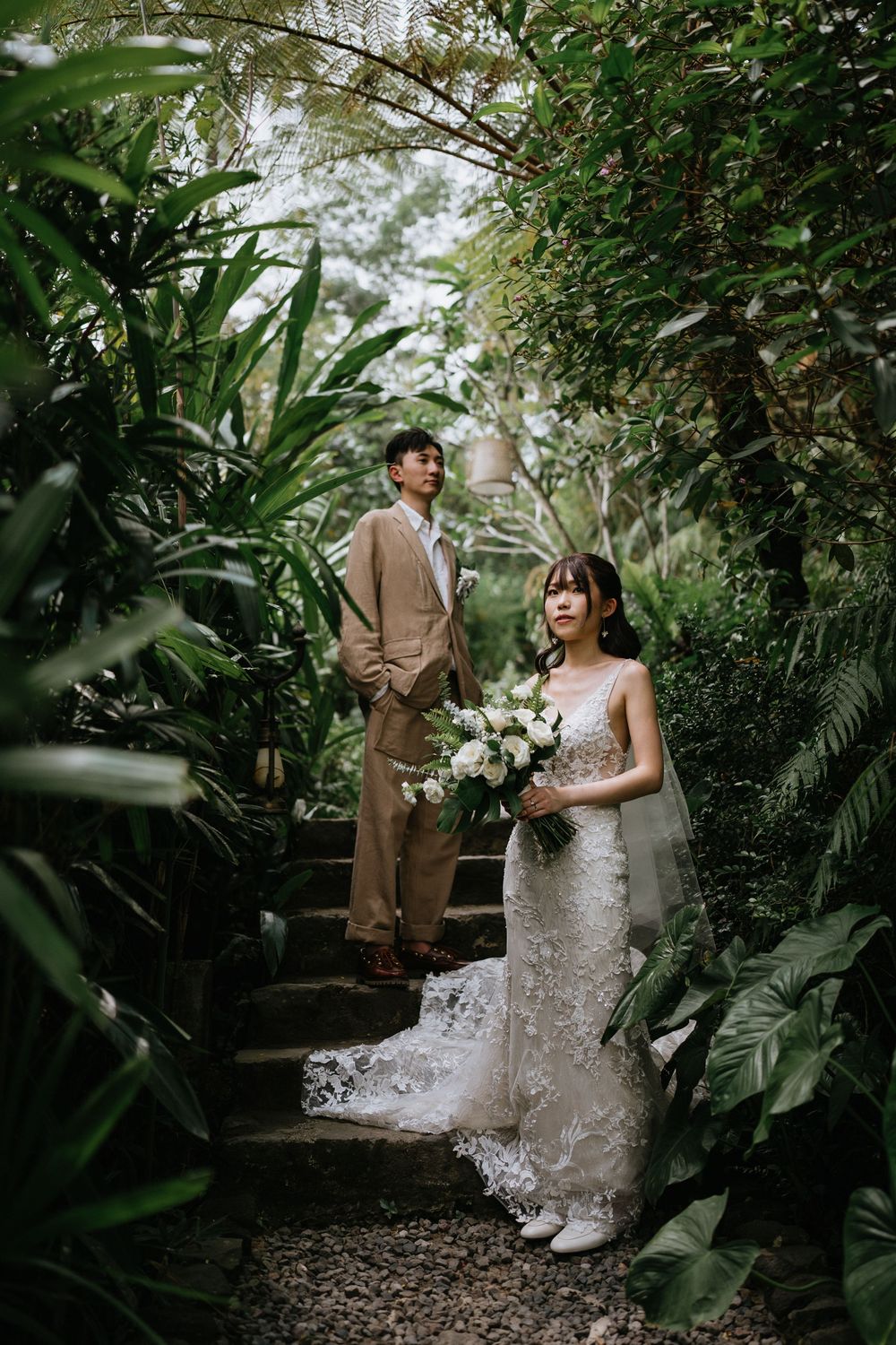 A romantic garden photoshoot with lush tropical plants and white florals creating a natural backdrop.