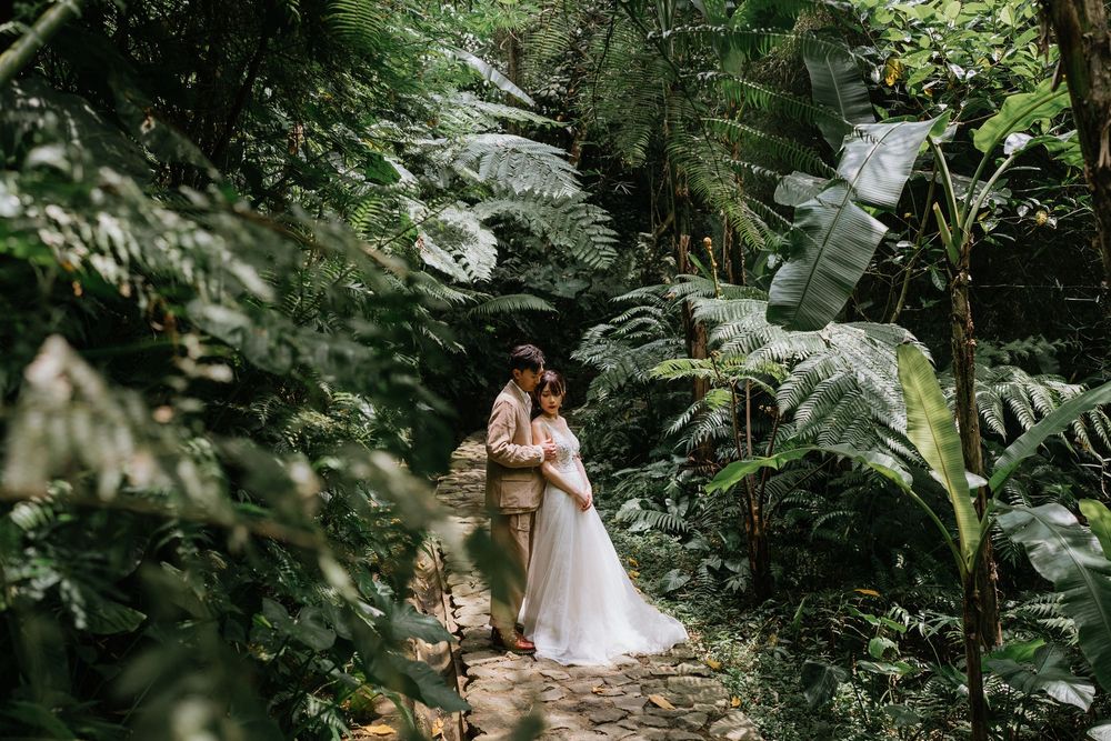 An intimate garden wedding moment captured among lush tropical foliage.