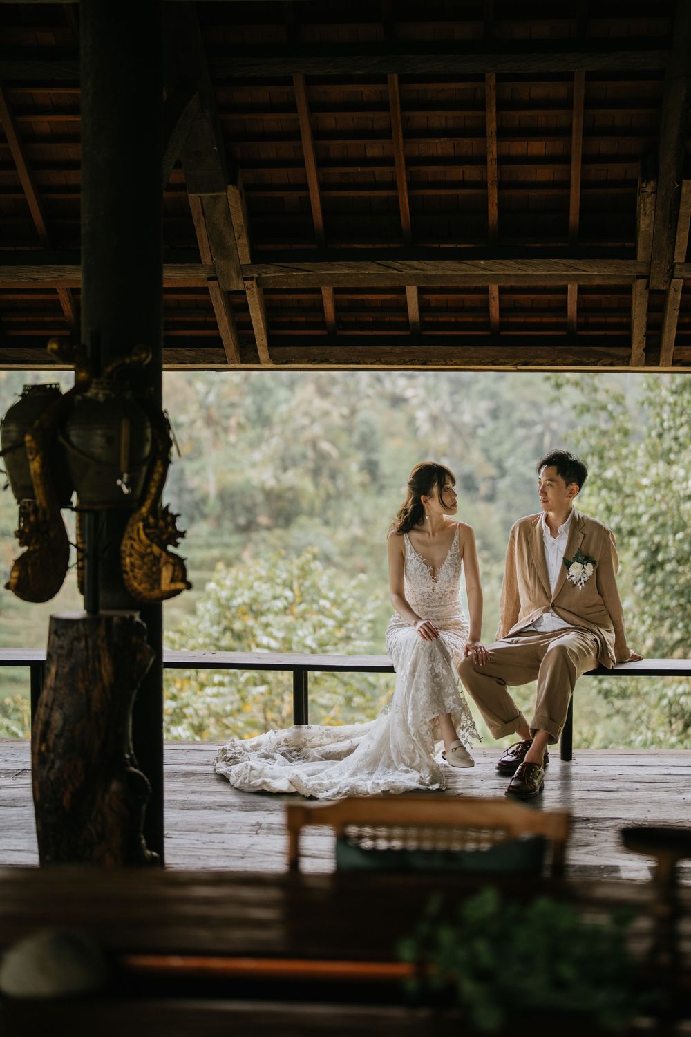 An intimate moment captured in a rustic wooden pavilion with natural lighting.