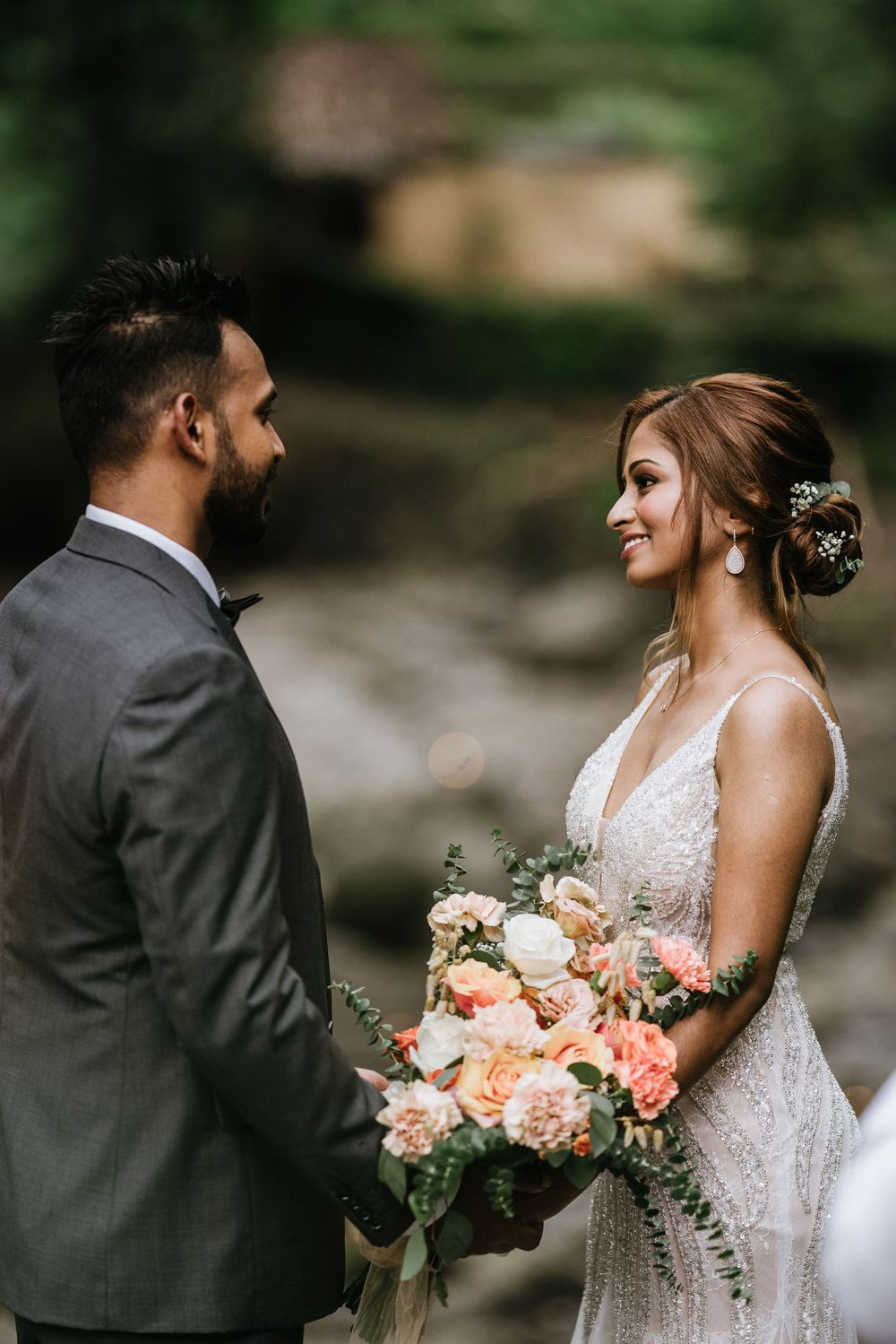 Intimate wedding couple moments captured in a natural outdoor setting with elegant floral details.