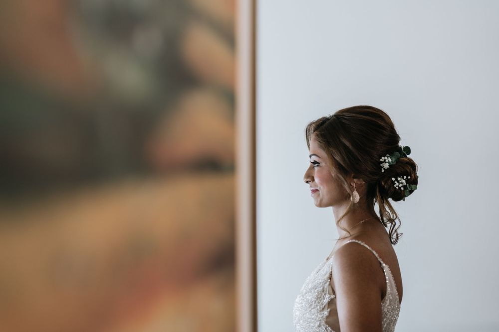 Elegant bridal details with pearl earrings and upswept hairstyle.