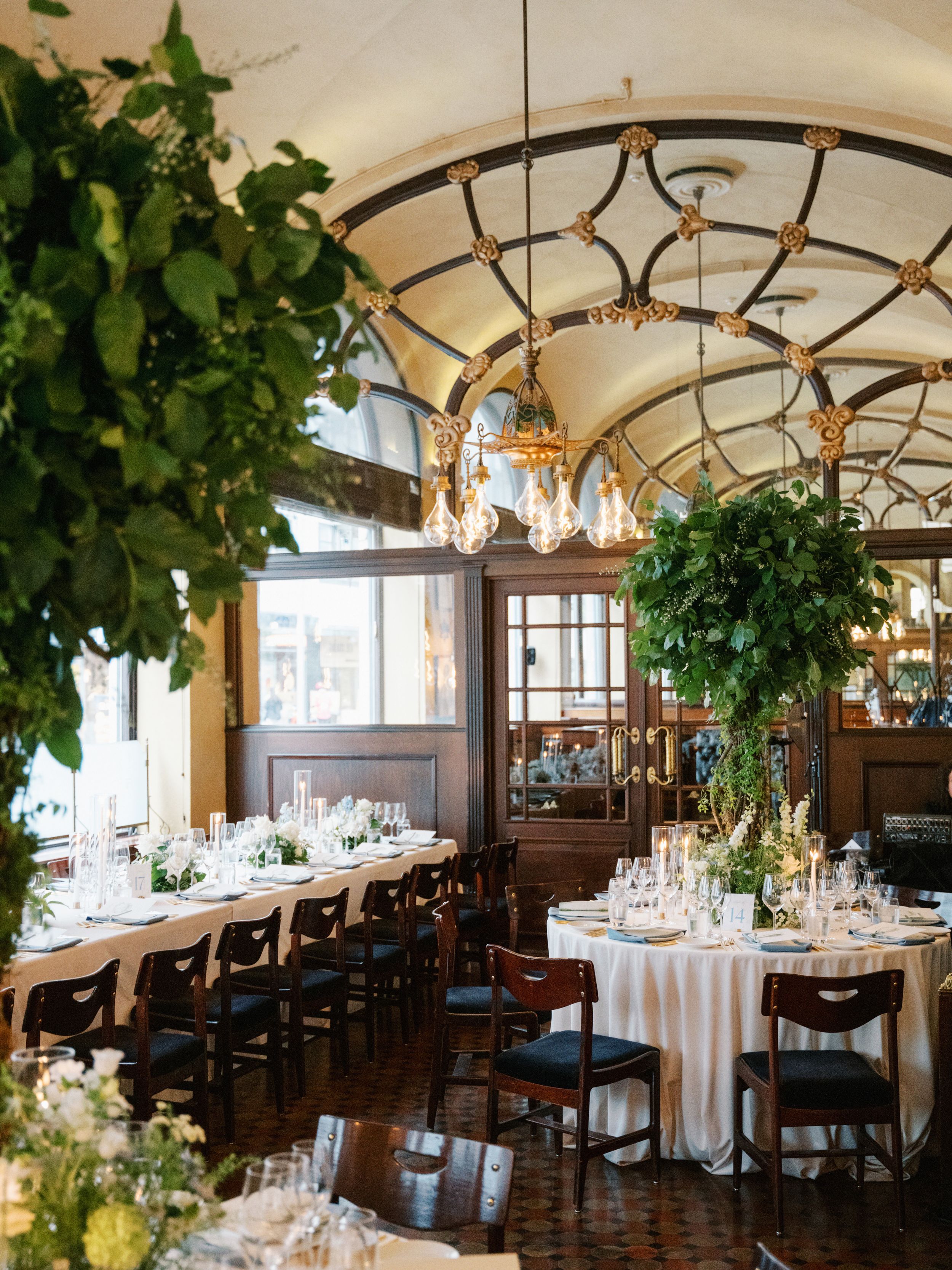 Elegant restaurant dining room with vaulted ceilings, chandeliers, and round tables set for a formal event.