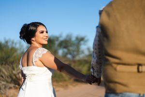 Romantic desert photoshoot with couple in casual attire against natural backdrop.