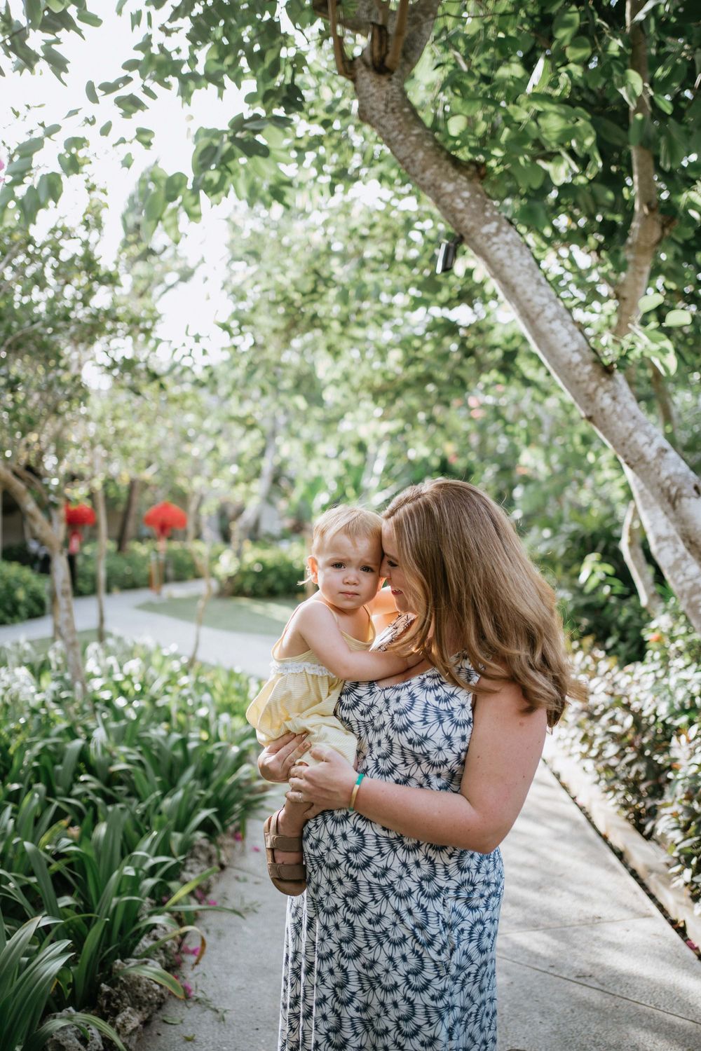 A candid moment of joy and laughter captured in a lush garden setting.