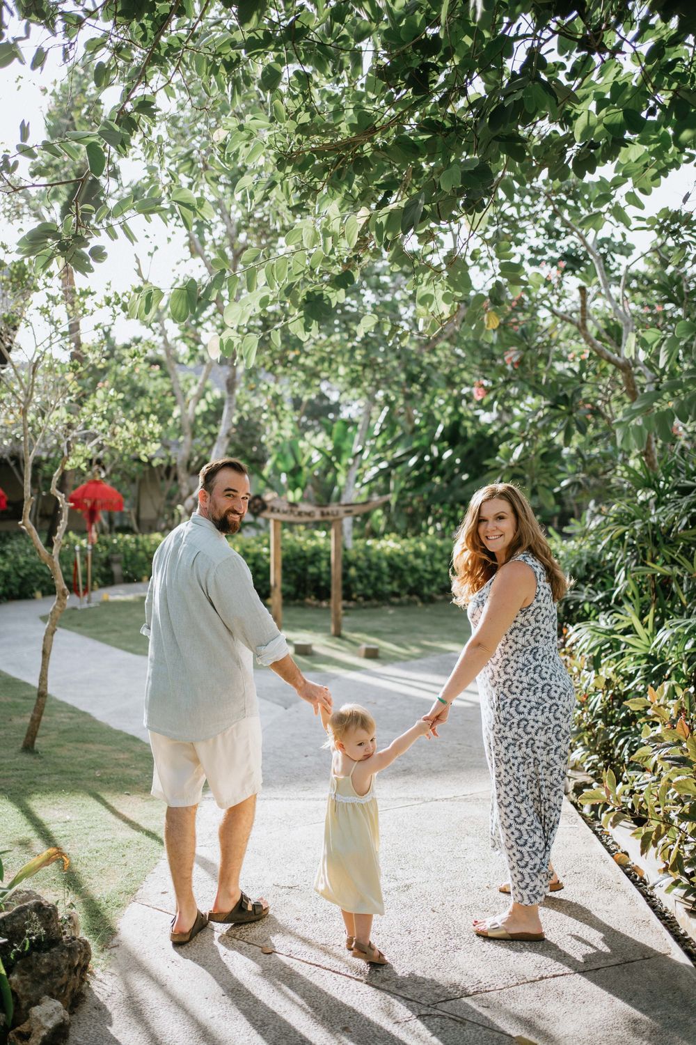 Candid family moments captured while walking together on a garden path.