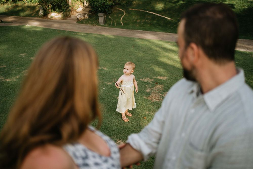 Candid moments of a family enjoying time together in a garden setting.