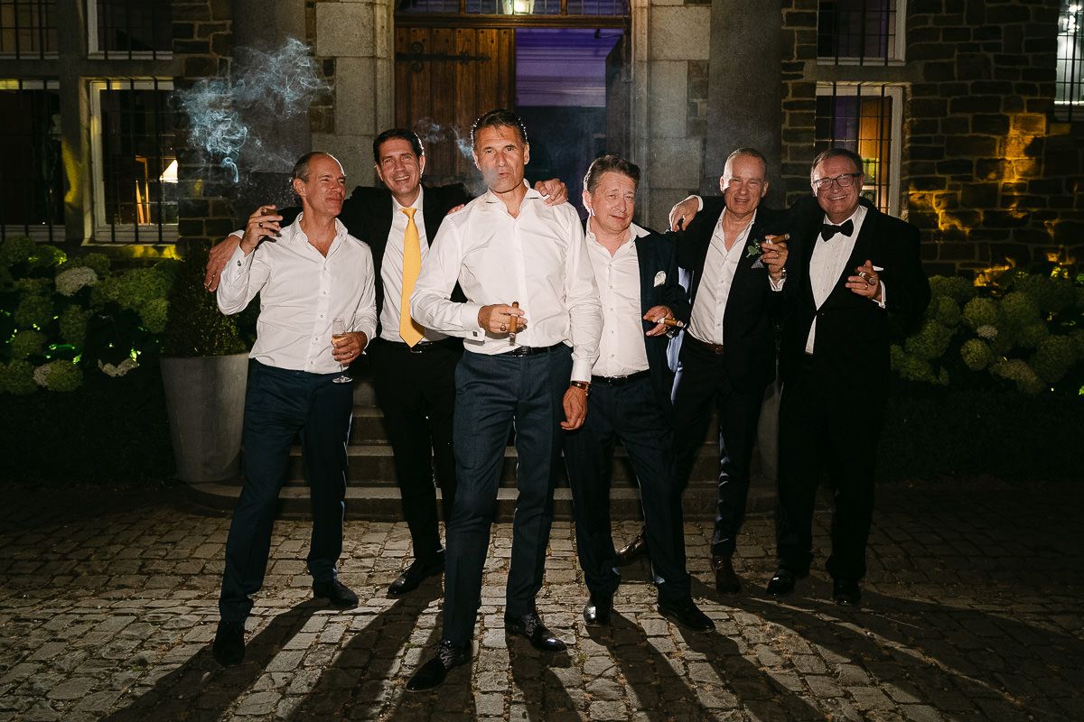 Groomsmen smoking cigars at Manoir de Lébioles wedding night