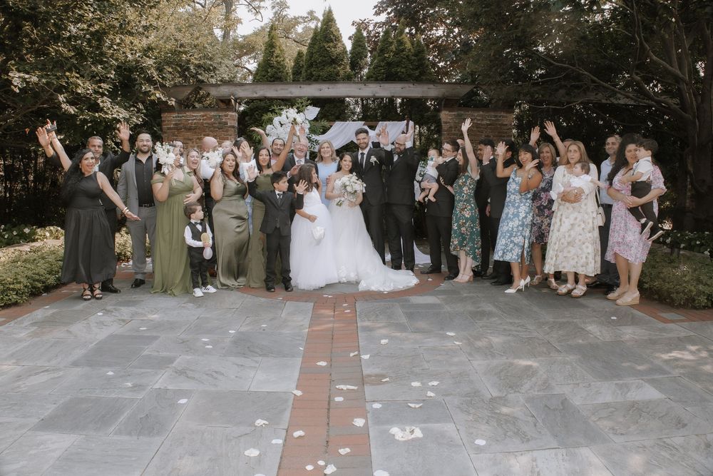 Wedding party members stand together for group photos outdoors during a celebratory gathering.