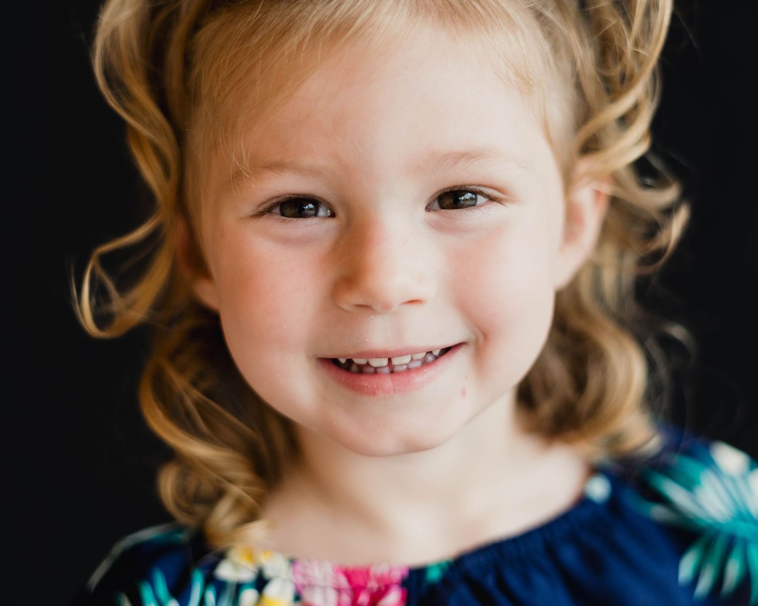 Smiling preschool girl in a Montessori classroom during a school portrait session in Palm Bay.