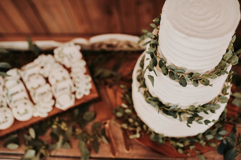 Romantic rustic barn reception with flickering candles and earthy florals surround the wedding cake