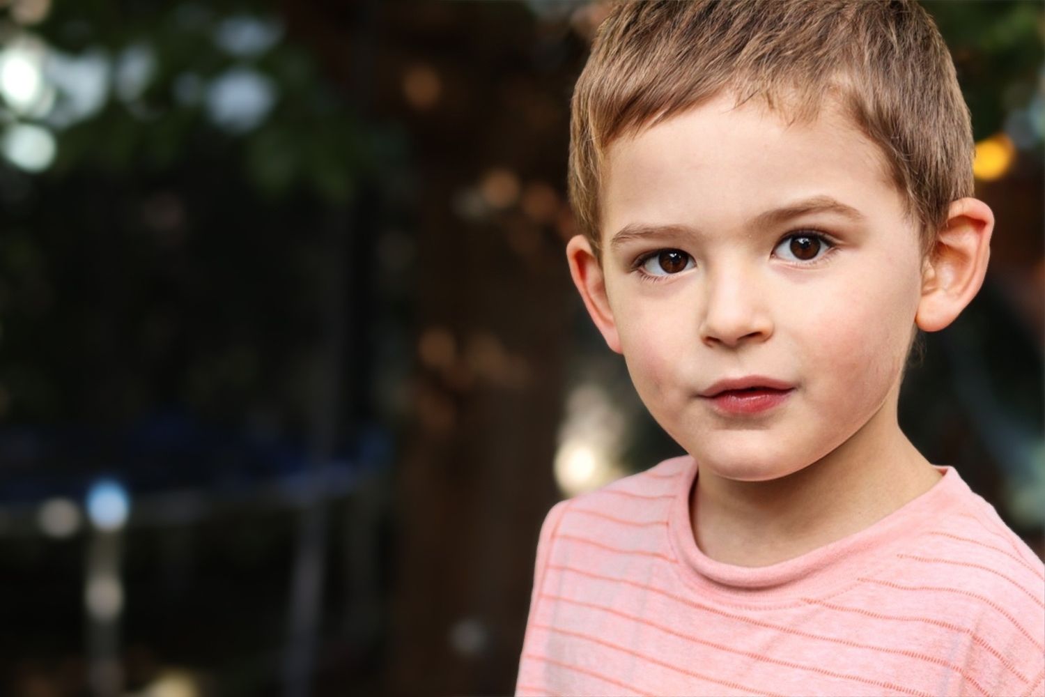 A series of close-up portrait shots showing a child wearing an orange ruffled top in an outdoor setting.