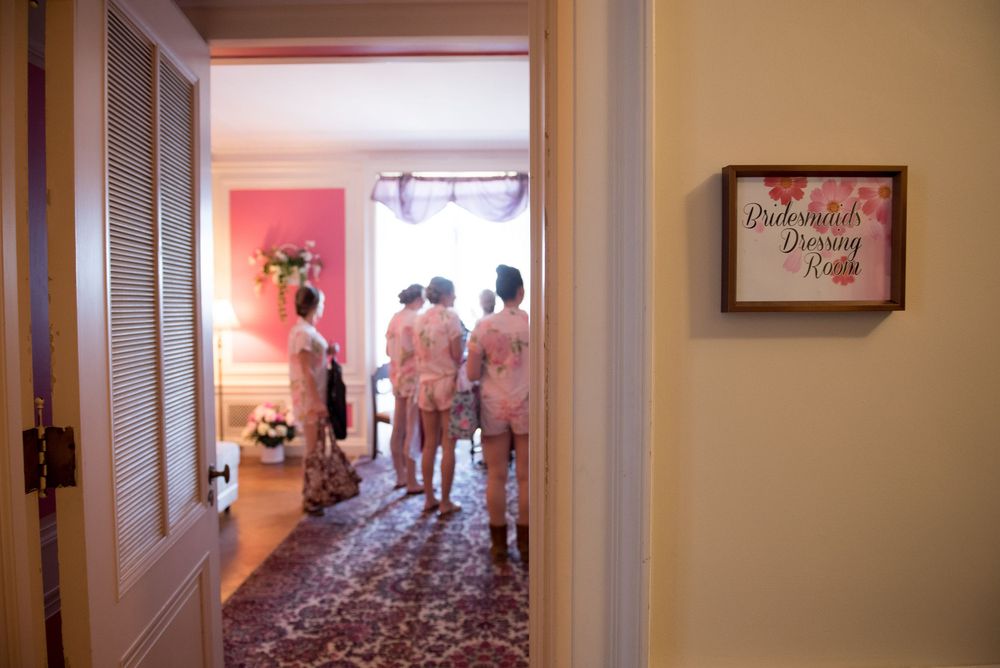 Interior hallway view with pink walls leading to a room with scattered rose petals.