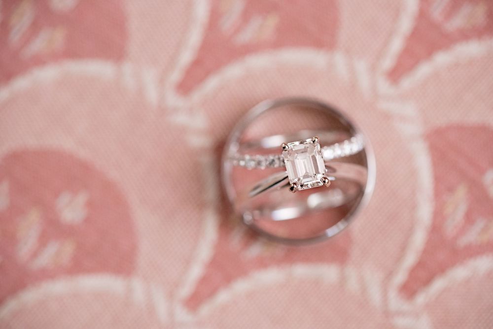 Diamond engagement ring photographed on pink patterned fabric.