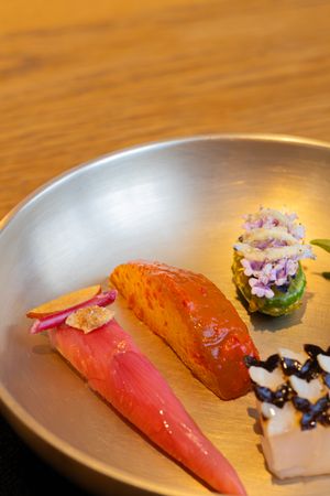 A series of progression shots showing various pieces of sushi being plated on a wooden surface against a warm background.