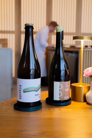 Two minimalist wine bottles with modern graphic labels displayed on a wooden table.