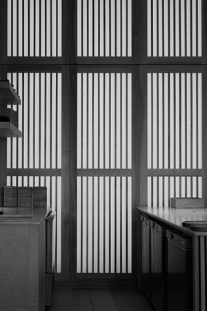 Modern interior space with vertical wooden slat panels creating a minimalist Japanese aesthetic.