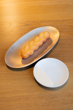 White oval plates with orange snacks arranged diagonally on wooden surface.