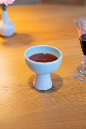 Small white ceramic sake cups or bowls arranged on a wooden table surface.