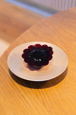 A deep purple flower-shaped gelatin dessert arranged on a white ceramic plate.
