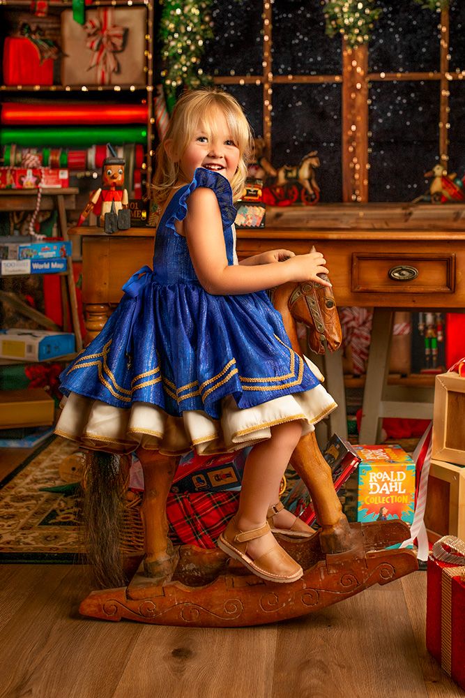 A series of photos showing boots and a blue dress against a festive holiday backdrop with Christmas decorations.