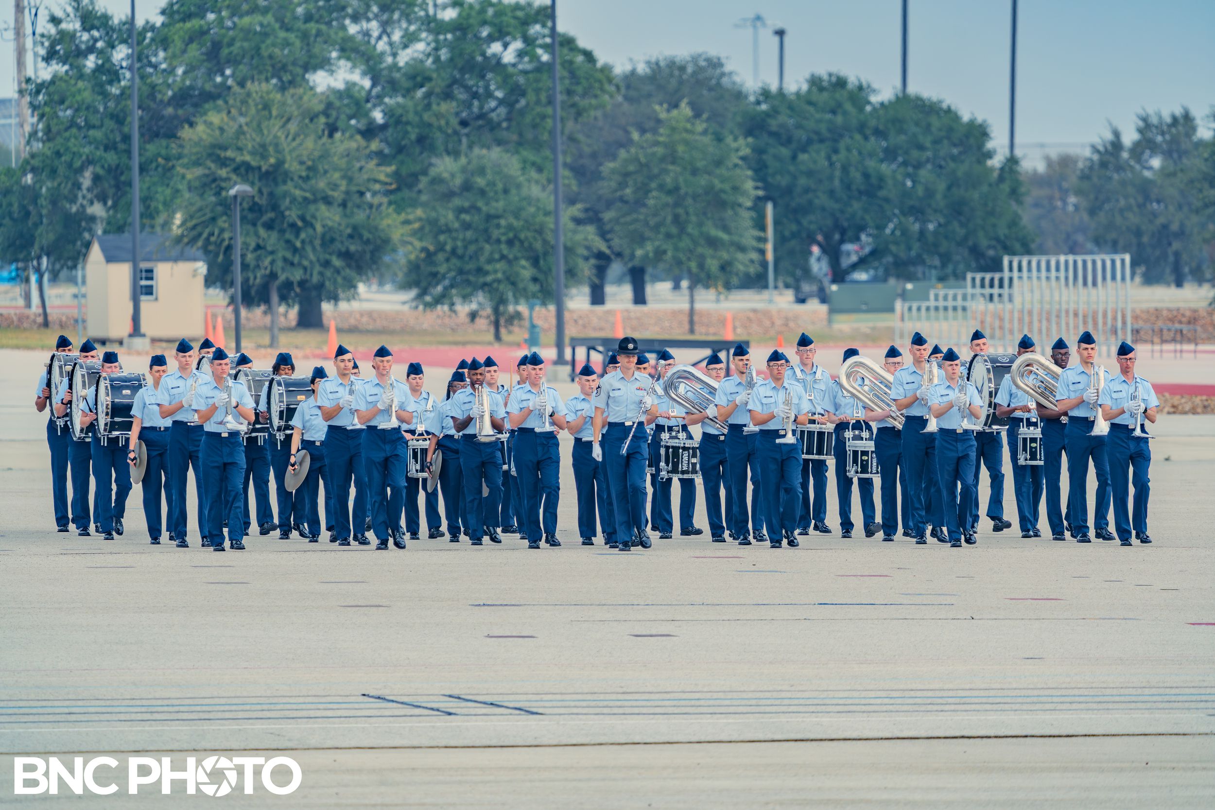 U.S. Air Force trainees standing in formation on the parade field during a graduation ceremony.”